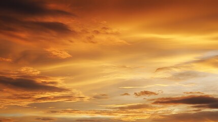 Fototapeta premium A golden sunset sky with orange and yellow clouds in high definition, vibrant gold hues adding depth, reflecting warmth and tranquility on the ground for an atmospheric natural backdrop.