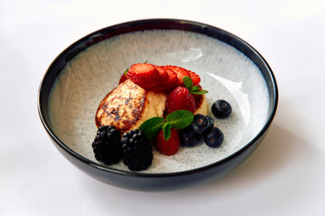 A Deliciously Plated Dessert Featuring Fresh Berries, Including Strawberries, Blueberries, Blackberries, and Raspberries Alongside a Creamy Base.