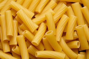 Close-up view of uncooked tortiglioni pasta arranged in a random pattern, showcasing the texture and shape of the pasta, ideal for culinary and food-related projects