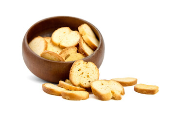 Crispy golden-brown bread slices are artistically arranged in a wooden bowl, with scattered pieces...