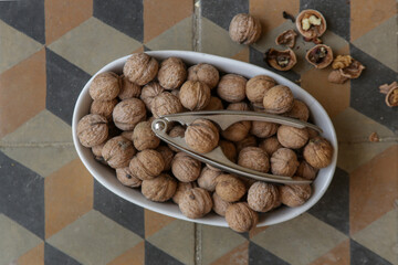 Whole and cracked walnuts and nutcracker
