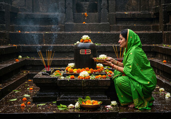 Woman in Green Saree Offering Bilva Leaves and Lotus on Shiva Lingam Amid Rain-Kissed Temple Steps