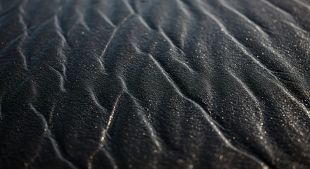 Detailed close-up view of dark sand patterns.