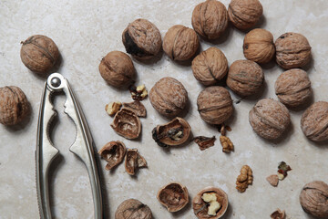 Whole and cracked walnuts and nutcracker