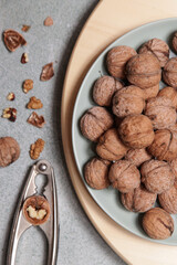 Whole and cracked walnuts and nutcracker