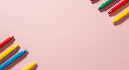 Fototapeta premium Set of Colorful Crayons Arranged on a Soft Pink Background
