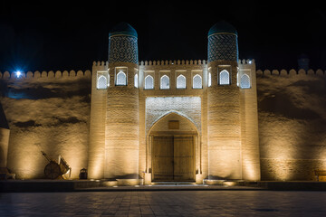 Night photo of the illuminated entrance to Ark Fortress in Khiva, Uzbekistan.