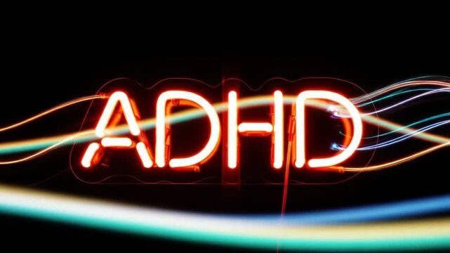 Glowing neon ADHD sign with light trails, symbolizing energy and movement.