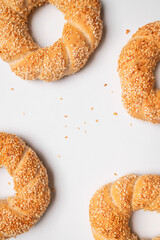 Simit or gevrek, round bagel with sesame seeds on white background top view. Traditional Turkish pastry, Istanbul street food. Delicious fresh homemade pastry, bakery product. Bagel mockup