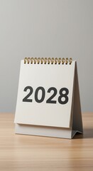 Modern 2028 tabletop calendar with minimalist design. Gold-spiral-bound planner for office or home. Clean and functional yearly calendar.
