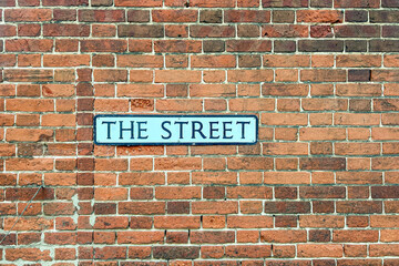 The Street road sign on a brick wall background
