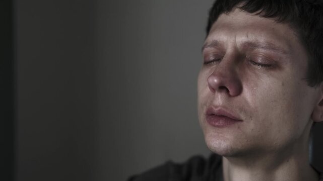 Emotions after breakup. Close-up of young man watching photos of his ex remembering happy moments together. Eyes full of tears, broken heart, loneliness.