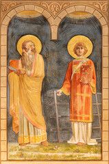 Obraz premium PIACENZA, ITALY - MAY 19, 2025: The fresco of St. Bartholomew the apostle and st. Lawrence in the Cathedral - Cattedrale di Santa Maria Assunta e Santa Giustina by Eugenio Cisterna from year 1901.
