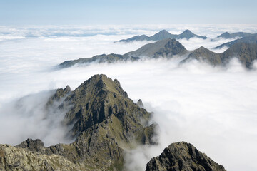 Mountain peaks surrounded by clouds, trekking in the mountains.
