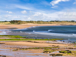 Embleton Bay, Northumberland, UK, one early morning in spring. Blue water, gentle waves, a few peple, very peaceful.