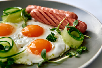 Delicious Breakfast Platter Featuring Sunny-Side-Up Eggs and Sausages Accompanied by Fresh Vegetables for a Nutritious Start to the Day