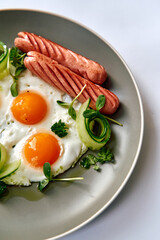 A Delicious Breakfast Plate Featuring Perfectly Cooked Eggs and Savory Sausages Accompanied by Fresh Vegetables for a Healthy Start to Your Day