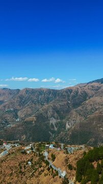 Aerial View of Mussoorie Hill Station. Dehradun district of the Indian state of Uttarakhand. Aerial Footage from Mussoorie. Mountains with blue sky and clouds in Mussoorie.