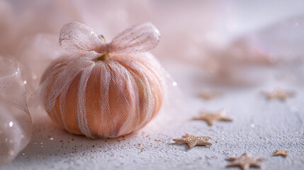 Elegant pastel pumpkin wrapped in glitter tulle with gold stars on textured surface, whimsical Halloween or autumn decor concept for seasonal creative projects