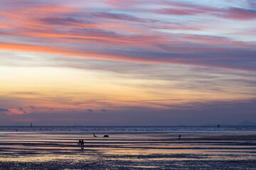 Fototapeta premium A stunning scene of a vivid sunset with pink and orange hues illuminating the sky over Karon beach Phuket. The serene water create a peaceful and atmospheric view