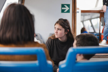 Young woman gazing thoughtfully while riding the ferry on a sunny day