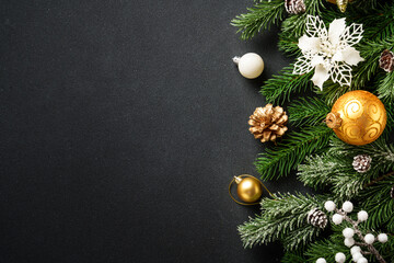 Christmas decorations and spruce tree at black background.