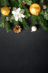 Christmas decorations and spruce tree at black background.