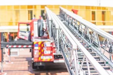 Fire truck with extendable ladder on paved surface, red and white, firefighting equipment, natural...