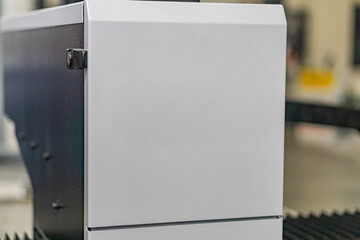 Industrial device with metallic surfaces, boxy shape, horizontal ridges, rounded corners, possibly...