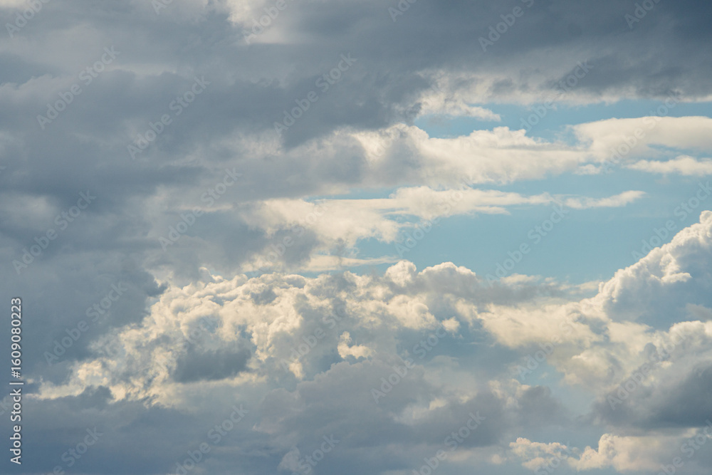 Poster overcast sky with various clouds, including cumulus and stratus formations, creating a layered effec