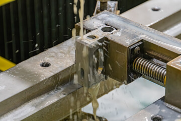 Industrial setting with a large, used metal fixture in focus Machine tools and components visible,...