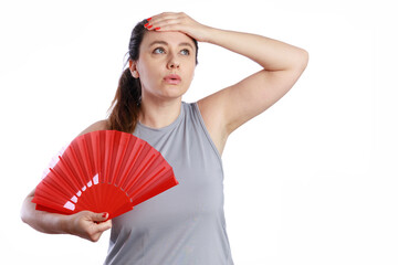 Woman cooling down using red hand fan