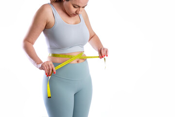 Young woman measuring her waistline