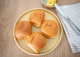 Freshly baked hot buns on a yellow plate. 
