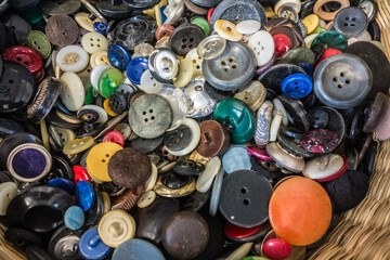 Vintage colorful background of old buttons in grandma's wicker sewing basket. Decorative pattern. Still life of colorful buttons. Collection of vintage buttons real photo.