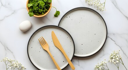 Overhead shot of plates with cutlery, egg, and cilantro on marble surface