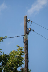 Wooden utility pole with wires and blue sky