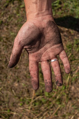 Dirty hand with wedding ring after work Vertical