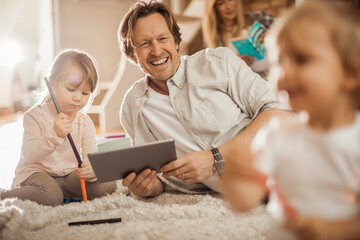 Family playing and using a tablet in the living room at home