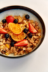 Colorful Bowl of Granola Topped with Fresh Berries and Dried Fruit for a Healthy Breakfast Option Filled with Nutrients and Flavor