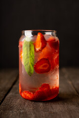 Refreshing summer cocktail with strawberries and rum on the rustic background. Selective focus.