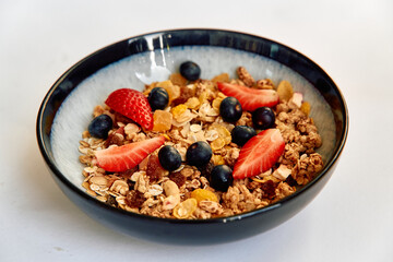 Delicious Bowl of Granola with Strawberries, Blueberries, and Dried Fruits Showcasing a Healthy Breakfast Option Rich in Nutrients and Flavor