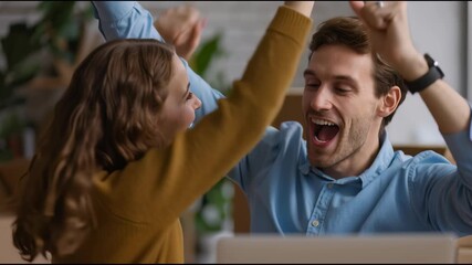 Joyful Duo Celebrates Victory: Capturing a moment of elation and triumph, a happy couple raises their arms in unison, symbolizing a shared accomplishment and the pure joy of success.