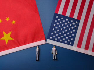 China and us america flag with miniature people on a blue background