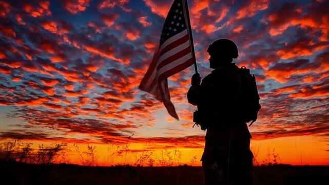Silhouette of a soldier holding the American flag with stunning sunset backdrop