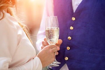 Close-up of a hand holding a glass of champagne. A loving couple on their wedding day.
