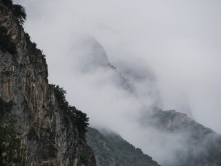 mountain ridge covered in clouds anf fog during a rainy autumn day