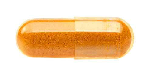 Dried turmeric powder capsule isolated on white.