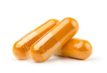 Dried turmeric powder capsules isolated on white.
