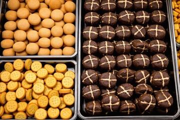 Assorted baked goods display featuring cookies and cross buns.